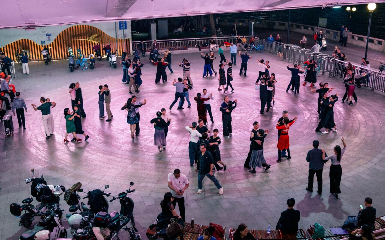 Grupo bailando en una plaza de noche
