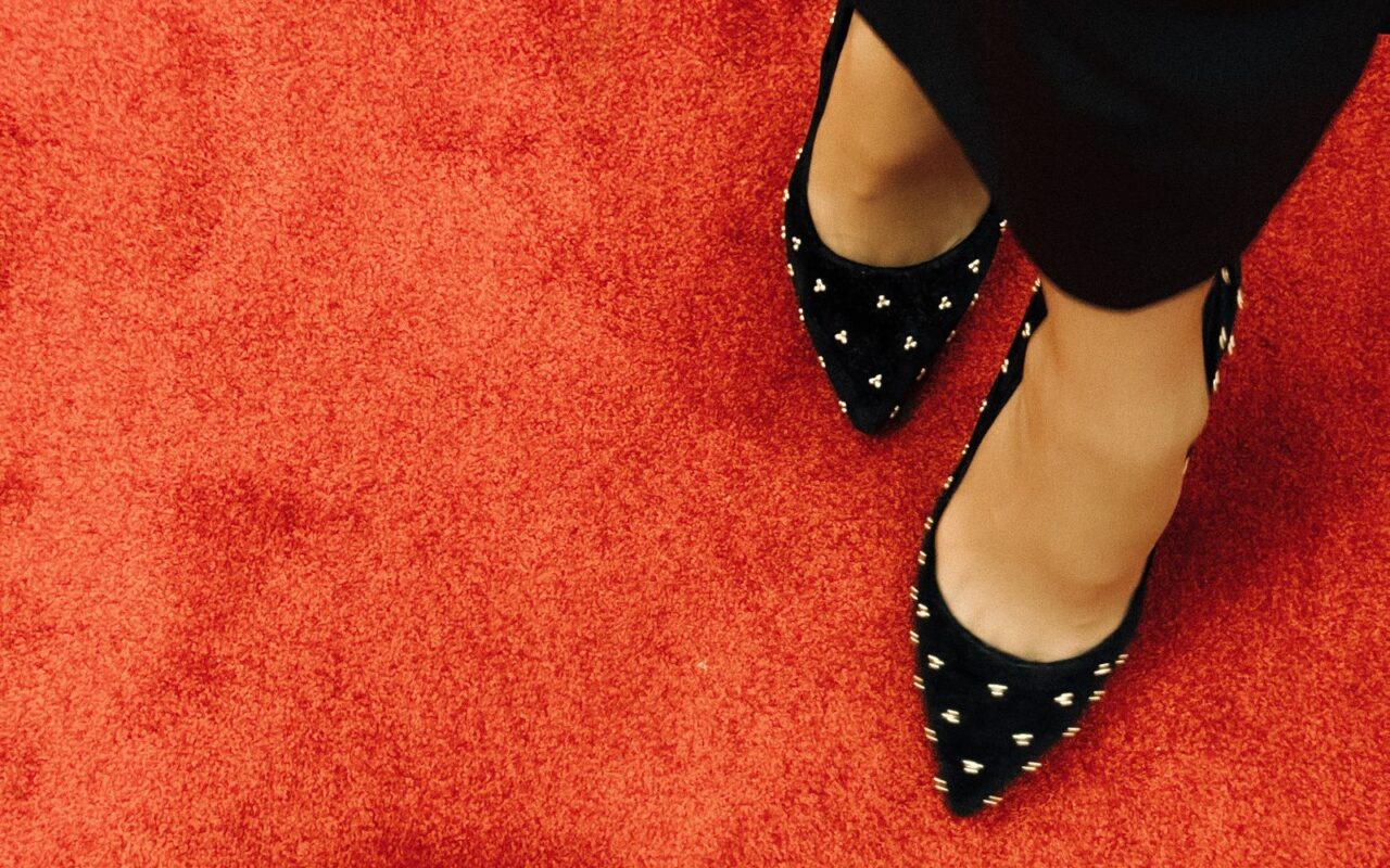 Tacones negros con tachas sobre la alfombra roja
