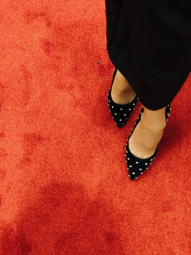 Tacones negros con tachas sobre la alfombra roja